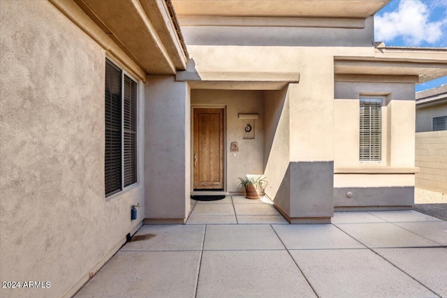 view of exterior entry featuring a patio area