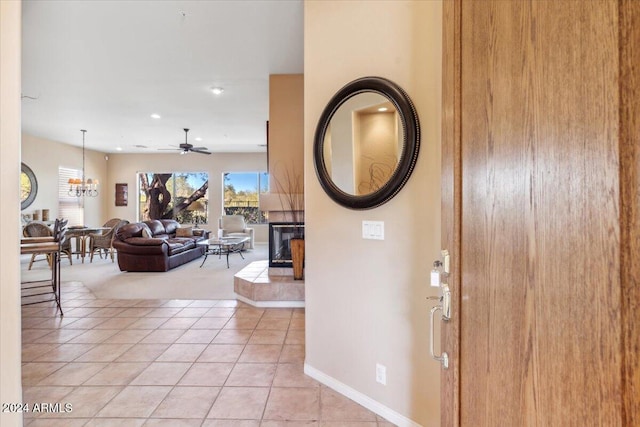 entryway featuring ceiling fan with notable chandelier and light tile patterned flooring