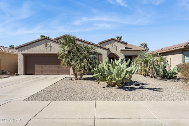 view of front of house featuring concrete driveway, an attached garage, and stucco siding