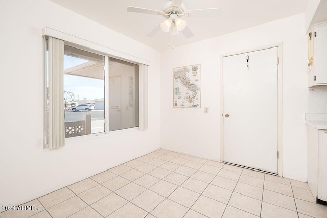 unfurnished room with light tile patterned floors and ceiling fan