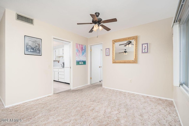 carpeted empty room featuring ceiling fan and sink