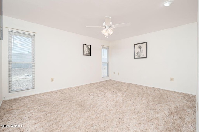 empty room with ceiling fan and light colored carpet