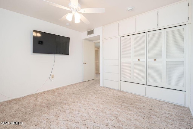 unfurnished bedroom featuring light carpet, a closet, and ceiling fan