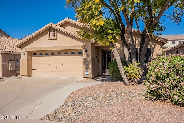 view of front of property featuring stucco siding, a garage, concrete driveway, and a tiled roof