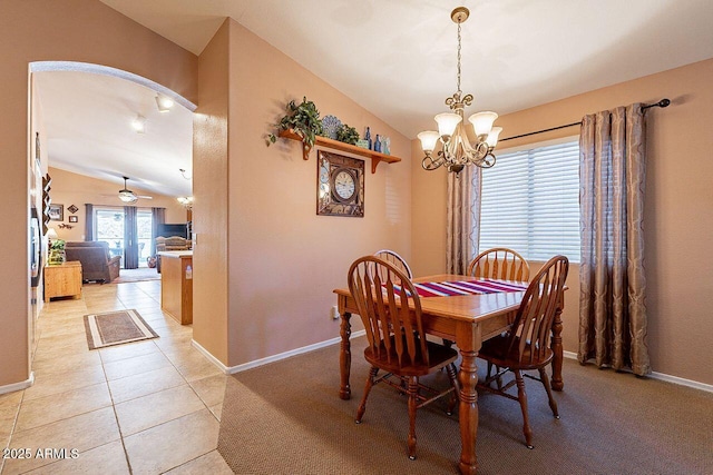 dining space with a chandelier, light tile patterned flooring, baseboards, and vaulted ceiling