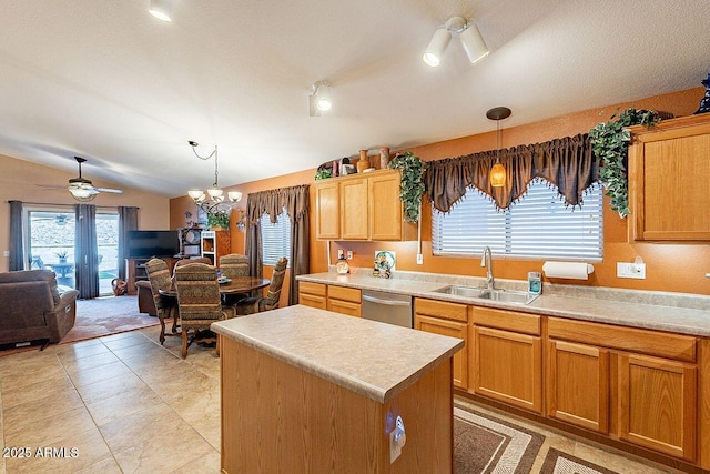 kitchen with a center island, pendant lighting, vaulted ceiling, stainless steel dishwasher, and a sink