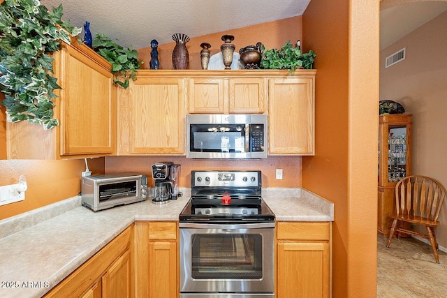 kitchen featuring stainless steel appliances, a toaster, visible vents, and light countertops