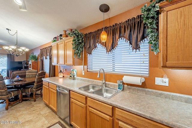 kitchen featuring a sink, pendant lighting, light countertops, a notable chandelier, and stainless steel dishwasher