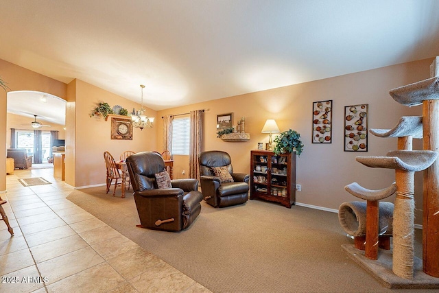 carpeted living room featuring tile patterned flooring, a notable chandelier, baseboards, and arched walkways