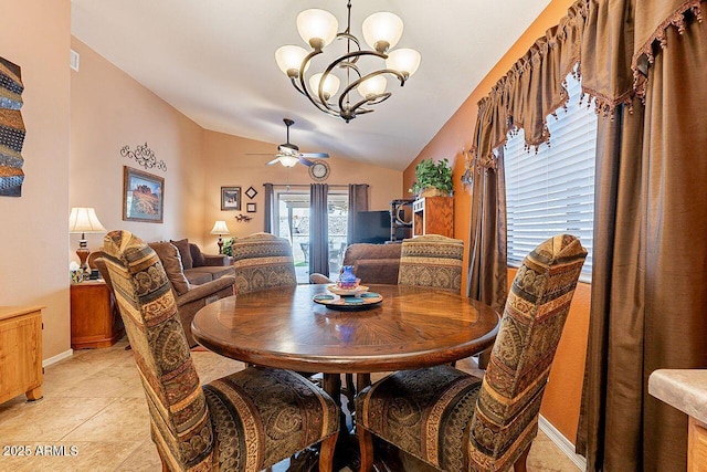 dining room featuring vaulted ceiling, ceiling fan with notable chandelier, and baseboards