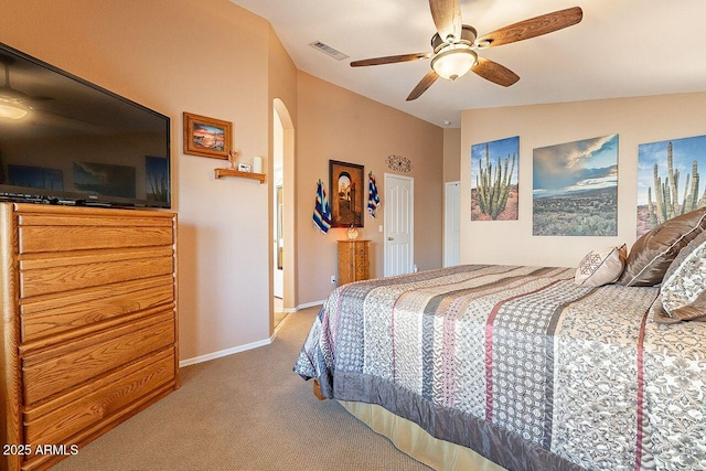 bedroom with visible vents, carpet floors, baseboards, lofted ceiling, and arched walkways