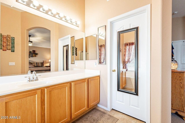 ensuite bathroom featuring tile patterned floors, ensuite bath, vanity, and a ceiling fan