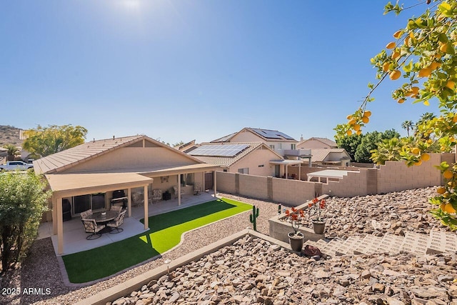 rear view of property with a fenced backyard, a tile roof, and a patio