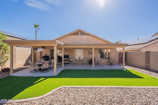 rear view of house featuring a patio area, stucco siding, a ceiling fan, and a fenced backyard