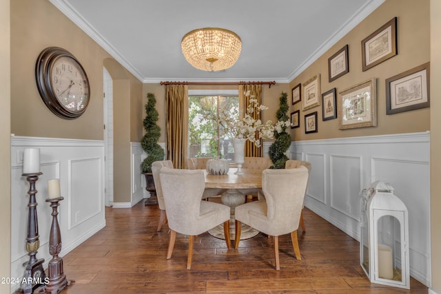 dining space featuring ornamental molding, dark wood-type flooring, and an inviting chandelier