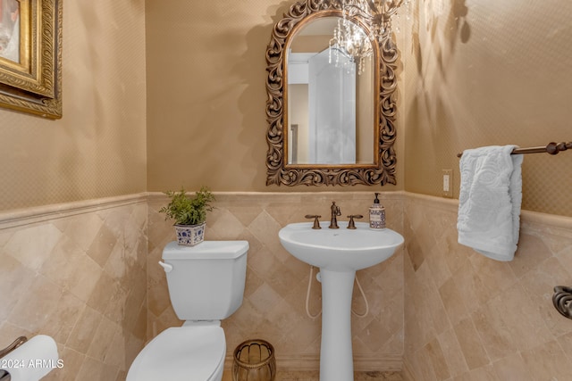 bathroom featuring sink, tile walls, and toilet