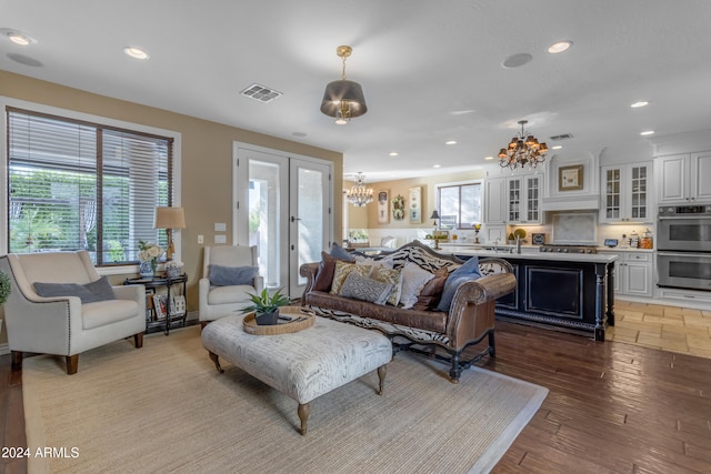 living room featuring a notable chandelier and light wood-type flooring