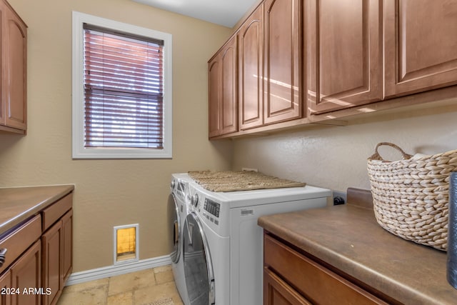 laundry room featuring cabinets and washing machine and clothes dryer