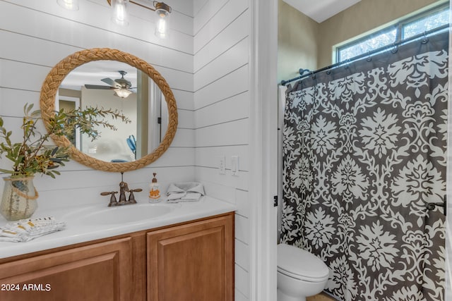 bathroom with curtained shower, ceiling fan, vanity, and toilet