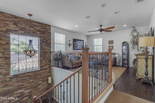 hallway with an inviting chandelier and dark hardwood / wood-style flooring