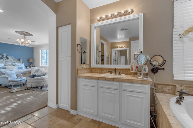 bathroom featuring tasteful backsplash, a notable chandelier, vanity, and tiled bath