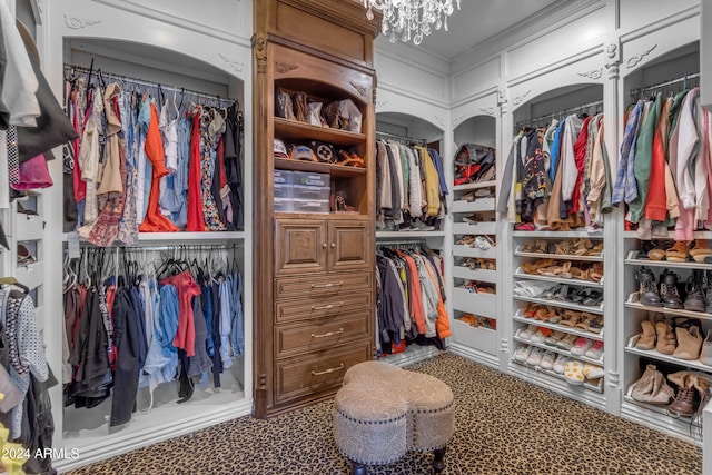 walk in closet with an inviting chandelier