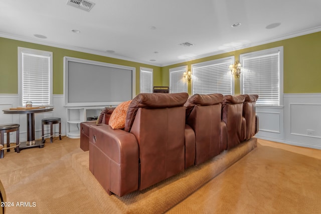 home theater room with light colored carpet and crown molding