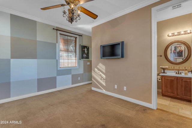 unfurnished bedroom with ceiling fan, connected bathroom, sink, light colored carpet, and crown molding