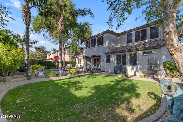 back of property with a yard and a patio