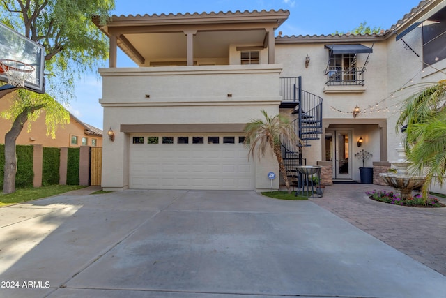 mediterranean / spanish-style home featuring a garage and a balcony