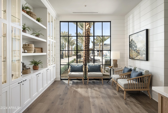 living area with hardwood / wood-style flooring and wooden walls