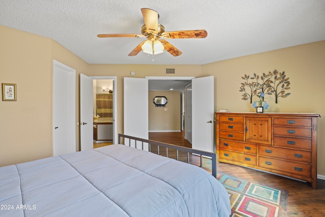 bedroom featuring a textured ceiling, connected bathroom, dark hardwood / wood-style floors, and ceiling fan