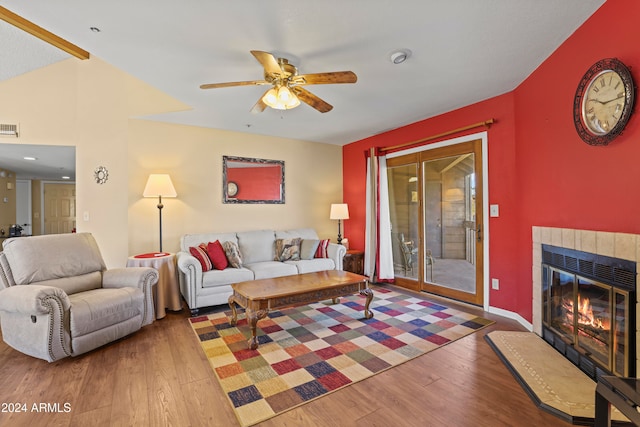 living room featuring a fireplace, wood-type flooring, vaulted ceiling, and ceiling fan