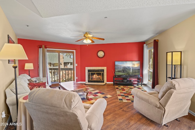 living room featuring a textured ceiling, hardwood / wood-style flooring, and ceiling fan