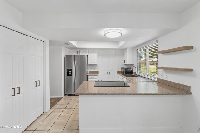 18206 N 45th Ave, Glendale, AZ 85308 - kitchen featuring stainless steel appliances, a raised ceiling, a peninsula, light tile patterned floors, and light countertops