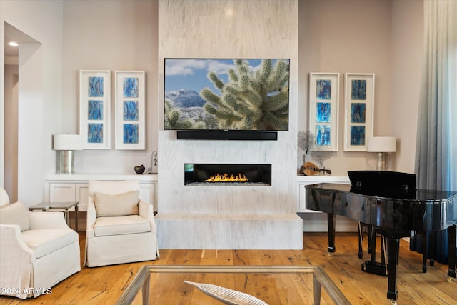 living room featuring hardwood / wood-style flooring and a glass covered fireplace