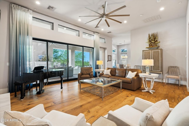 living room with light wood finished floors, baseboards, visible vents, and recessed lighting