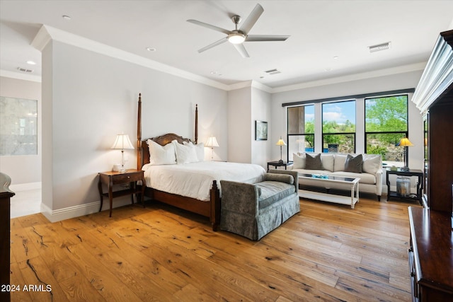 bedroom with ornamental molding, baseboards, visible vents, and light wood finished floors