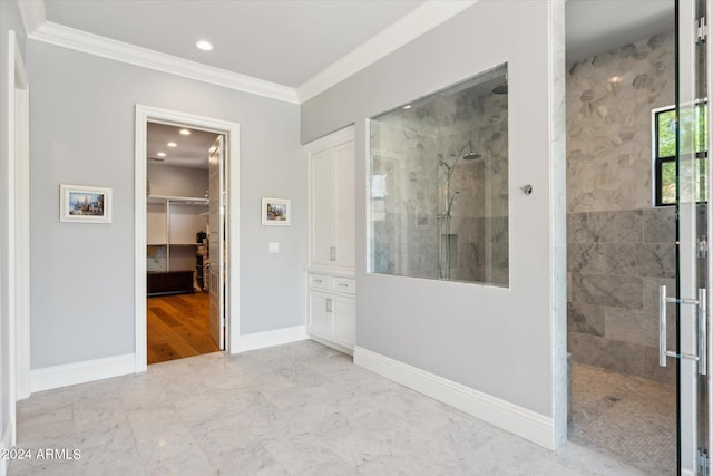 interior space featuring baseboards, marble finish floor, a walk in closet, crown molding, and a closet