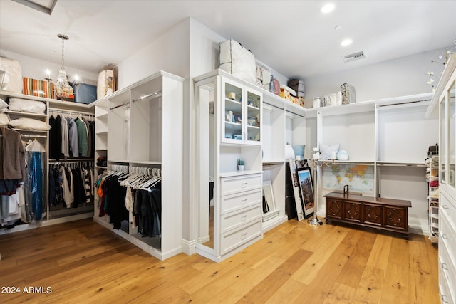 walk in closet featuring a chandelier, visible vents, and light wood-style floors