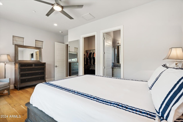 bedroom with light wood finished floors, recessed lighting, a closet, a spacious closet, and connected bathroom