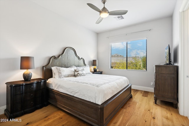 bedroom with light wood-style floors, visible vents, ceiling fan, and baseboards