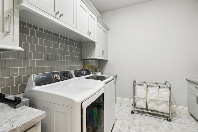 laundry area with light tile patterned flooring, cabinet space, baseboards, and separate washer and dryer