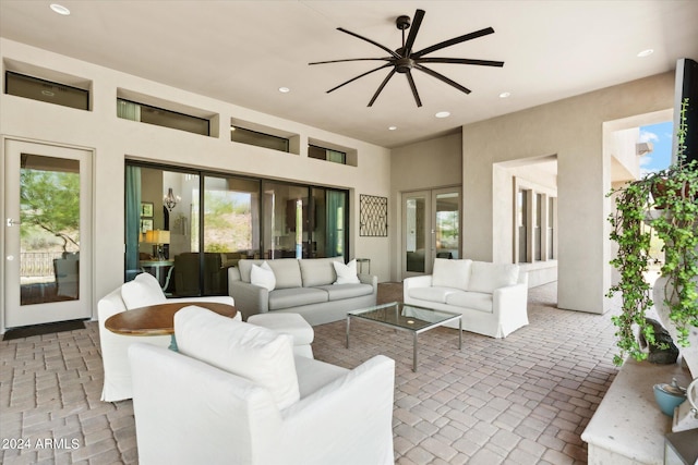 living room with a towering ceiling, brick floor, ceiling fan, and recessed lighting