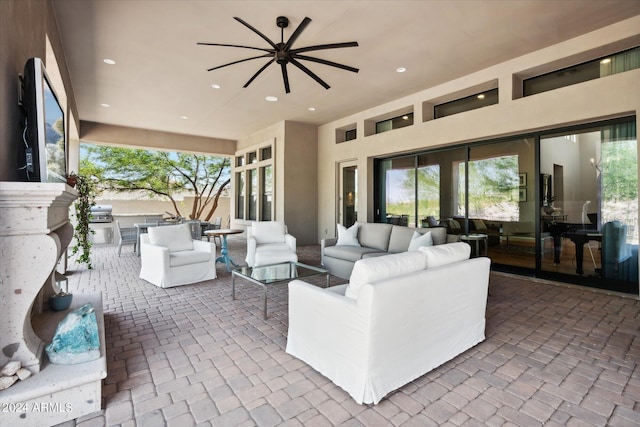 view of patio featuring ceiling fan, an outdoor kitchen, and an outdoor living space