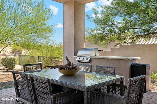 view of patio / terrace with outdoor dining area, area for grilling, a grill, and fence