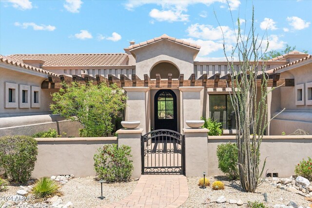 view of front of property with a fenced front yard, a gate, and stucco siding