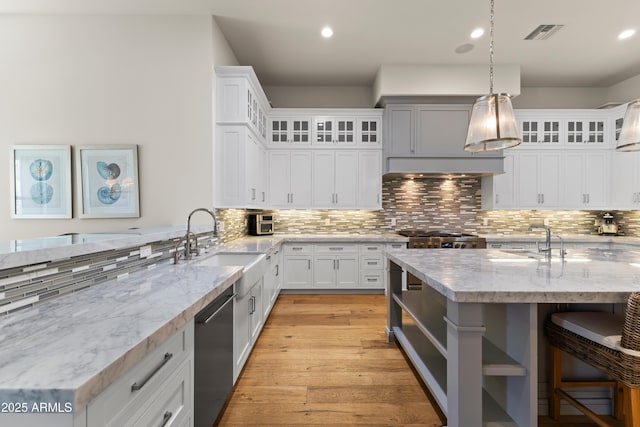 kitchen featuring visible vents, dishwasher, light wood-style floors, a sink, and recessed lighting