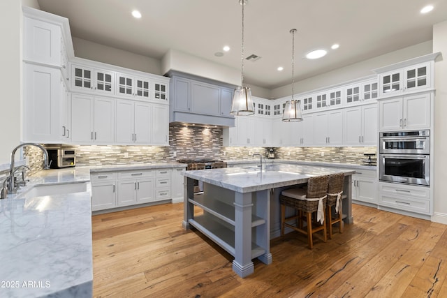 kitchen featuring stainless steel appliances, white cabinets, visible vents, and a sink