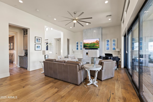 living area with baseboards, recessed lighting, visible vents, and light wood-style floors